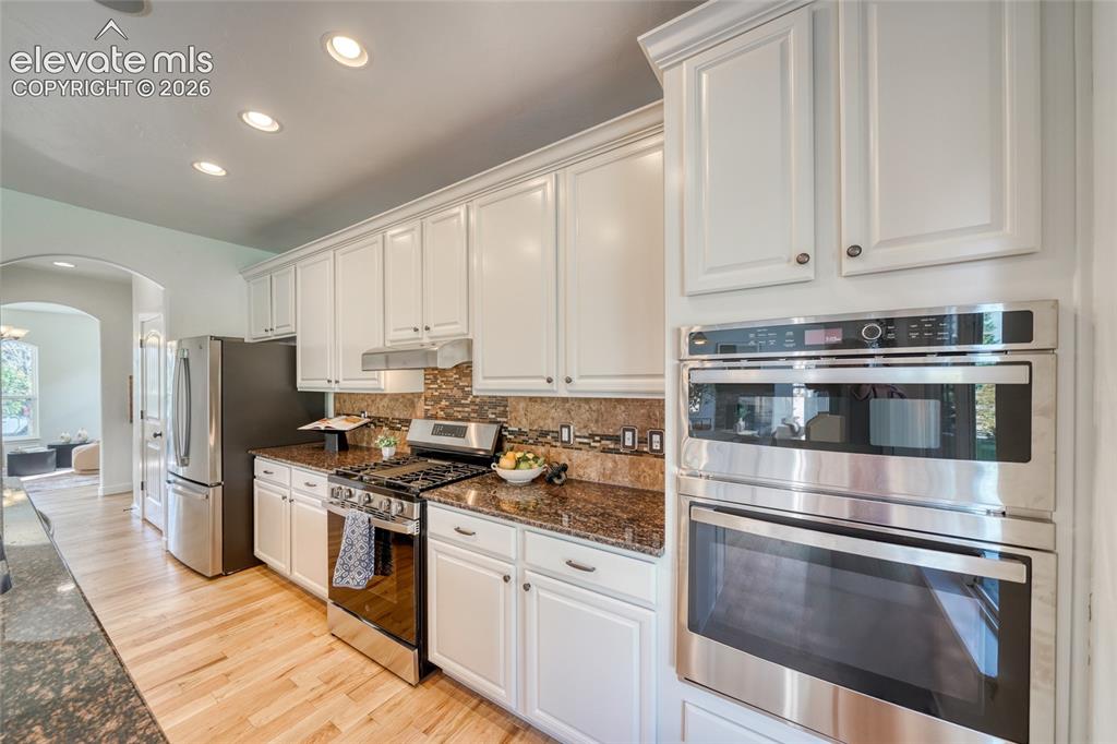 Image 16 of 49: White cabinetry with crown molding, stainless steel appliances, a built-in 