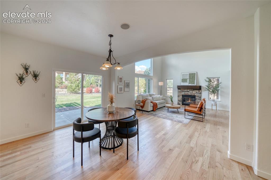 Image 18 of 49: Hardwood flooring throughout, recessed lighting, and a stone fireplace with