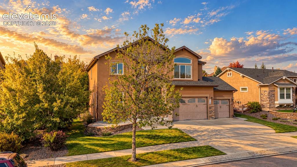 Image 2 of 49: Two-story stucco exterior, arched window, attached two-car garage, concrete