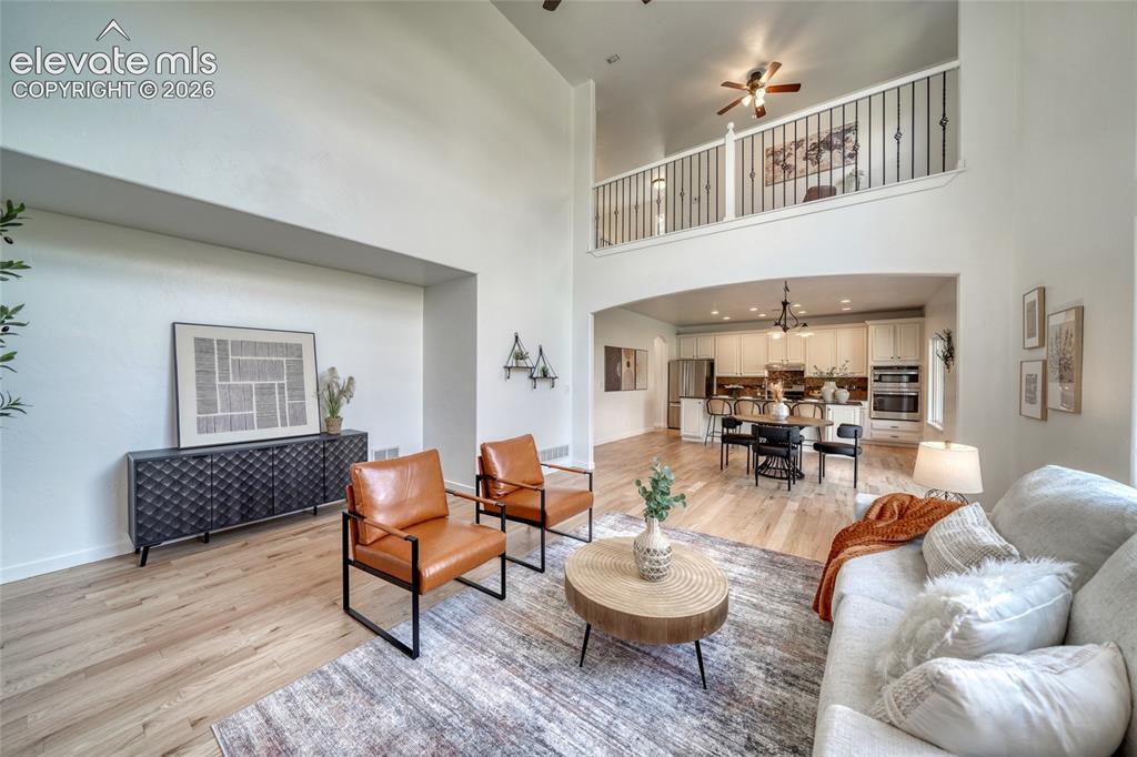 Image 21 of 49: Vaulted ceiling with an open loft, light wood-finish flooring, and a kitche