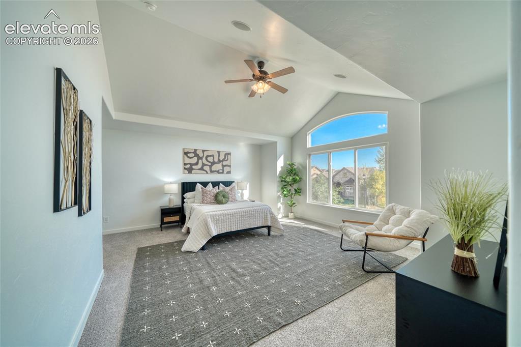Image 24 of 49: Vaulted ceilings and an arched window provide architectural interest
