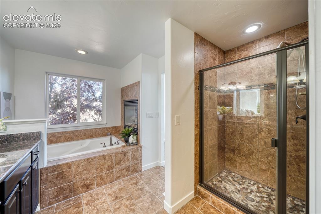 Image 27 of 49: Built-in soaking tub with surrounding tile, separate shower enclosure with