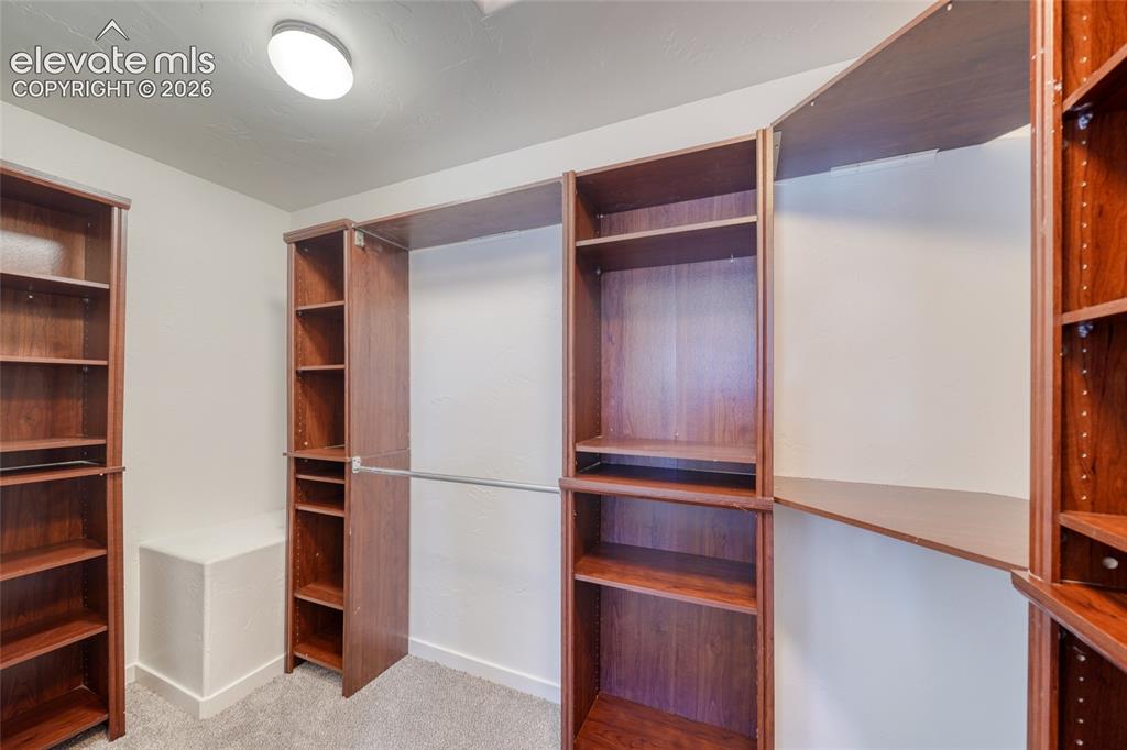 Image 28 of 49: Built-in wood-finish shelving and hanging rods