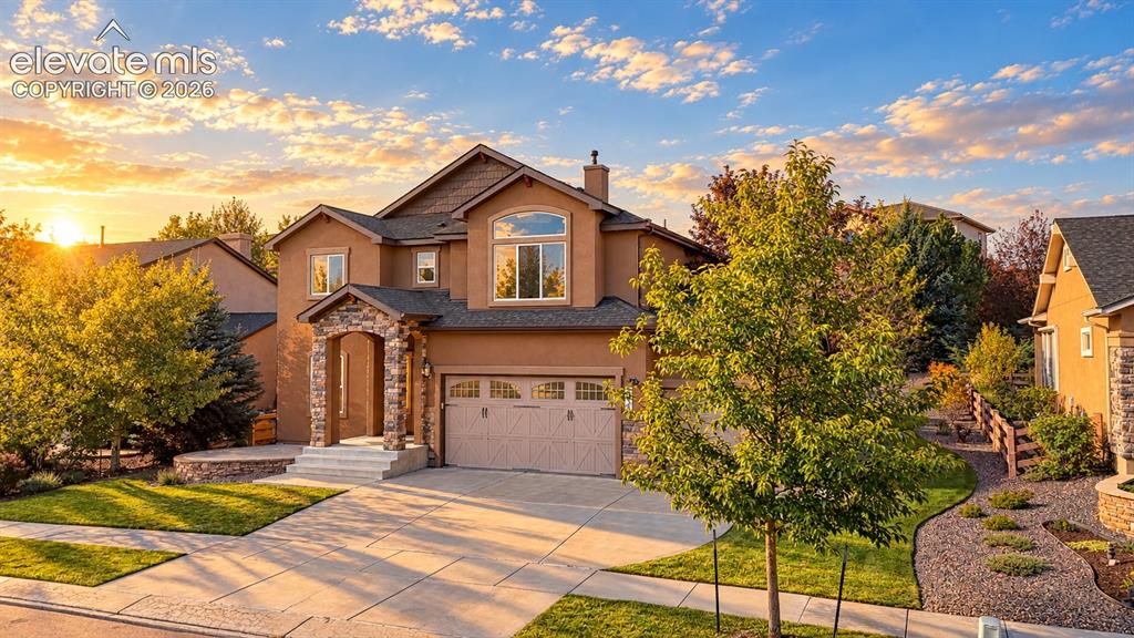 Image 3 of 49: Stucco exterior with stone accents, arched entryway, attached two-car garag