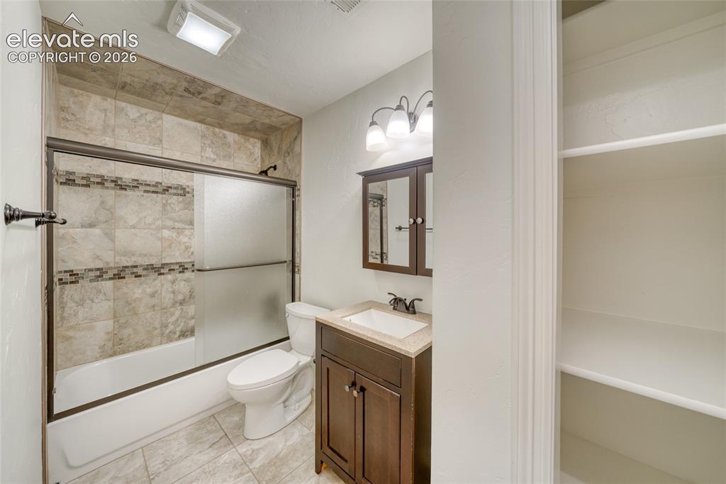 Image 40 of 49: Bathroom featuring a tiled shower surround with decorative accent, a bathtu