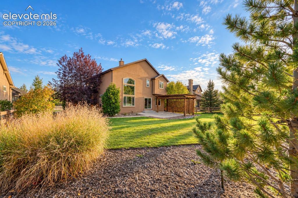 Image 47 of 49: Elegant two-story residence with stucco exterior and arched window detailin