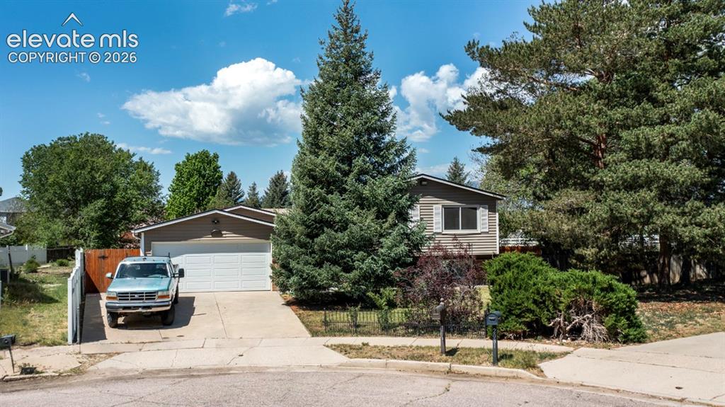 Image 1 of 42: Split-level residence featuring a two-car garage, concrete driveway, and ma