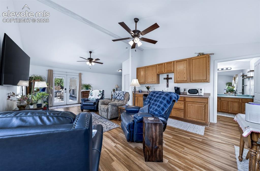 Image 13 of 42: Main Floor- Living area featuring vaulted ceilings, wood-finish flooring, t