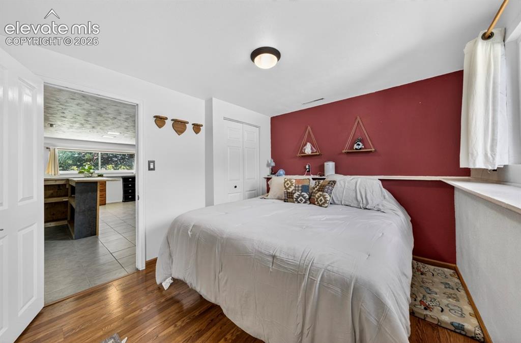 Image 19 of 42: Basement- Room featuring a striking accent wall, wood-finish flooring, and