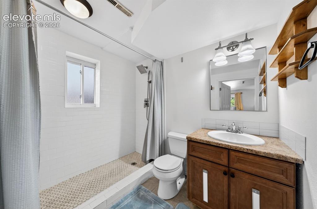 Image 21 of 42: Ensuite Bathroom featuring a walk-in shower with white subway tile walls an
