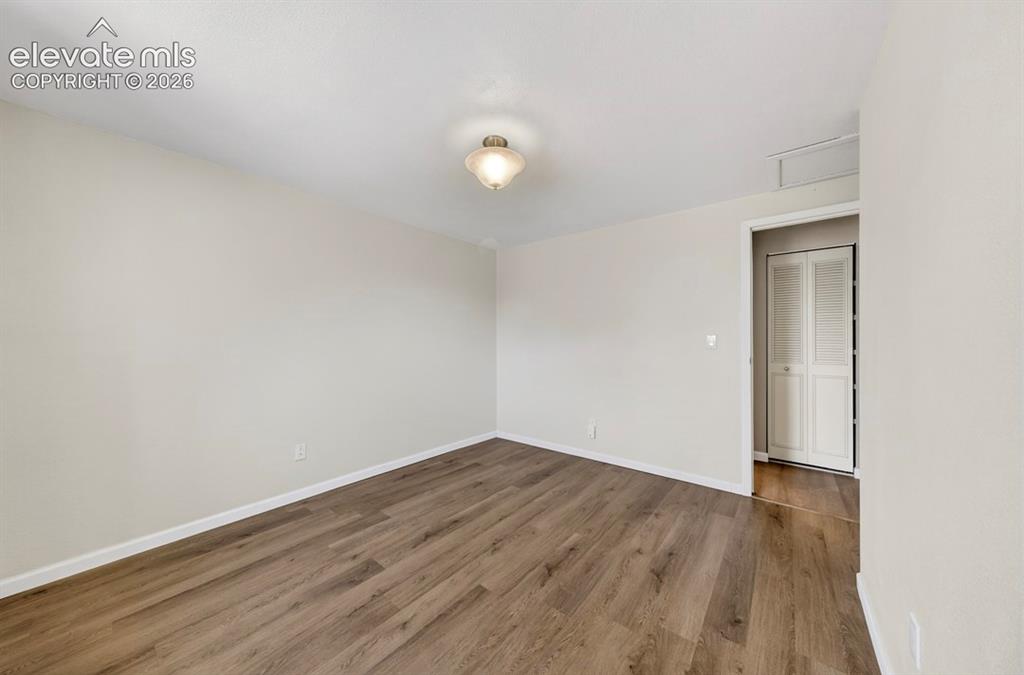 Image 27 of 42: Upper Level- Spacious interior room featuring wood-finish flooring, light n