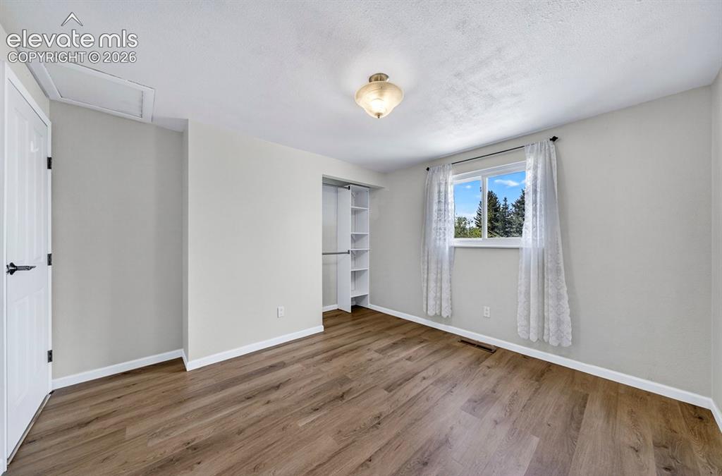 Image 28 of 42: Upper Level- Spacious room featuring wood-finish flooring, a window with ex