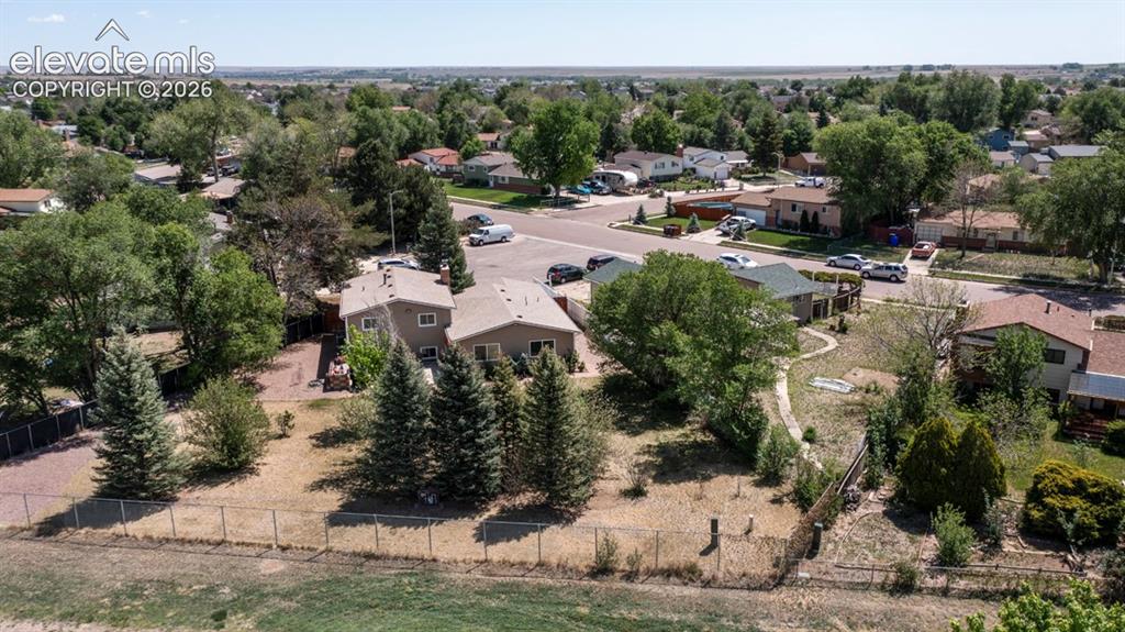 Image 37 of 42: Aerial perspective showcasing two properties with gray siding and brown roo