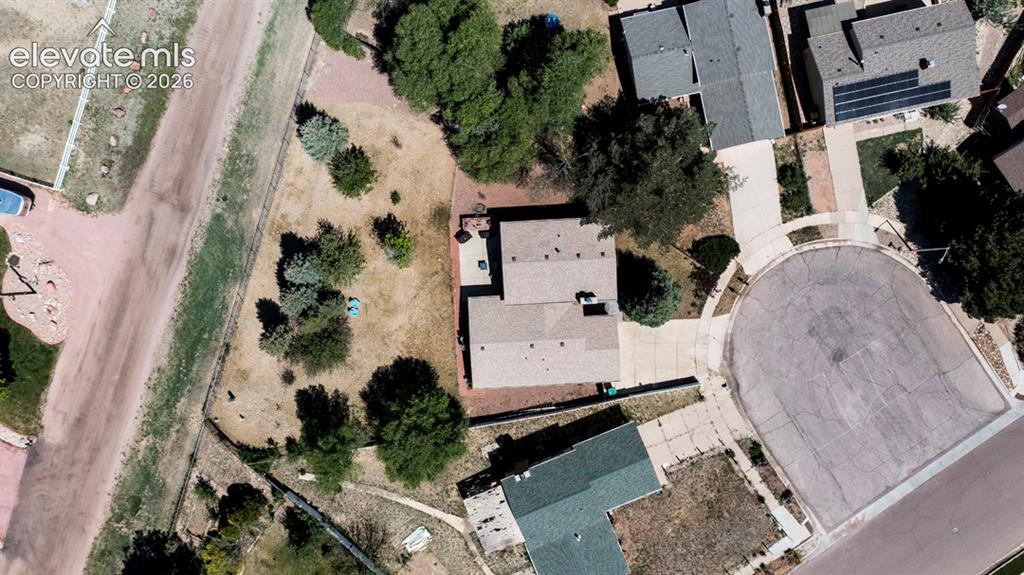 Image 38 of 42: Single-story residence with a brown shingle roof, a paved driveway, and mat