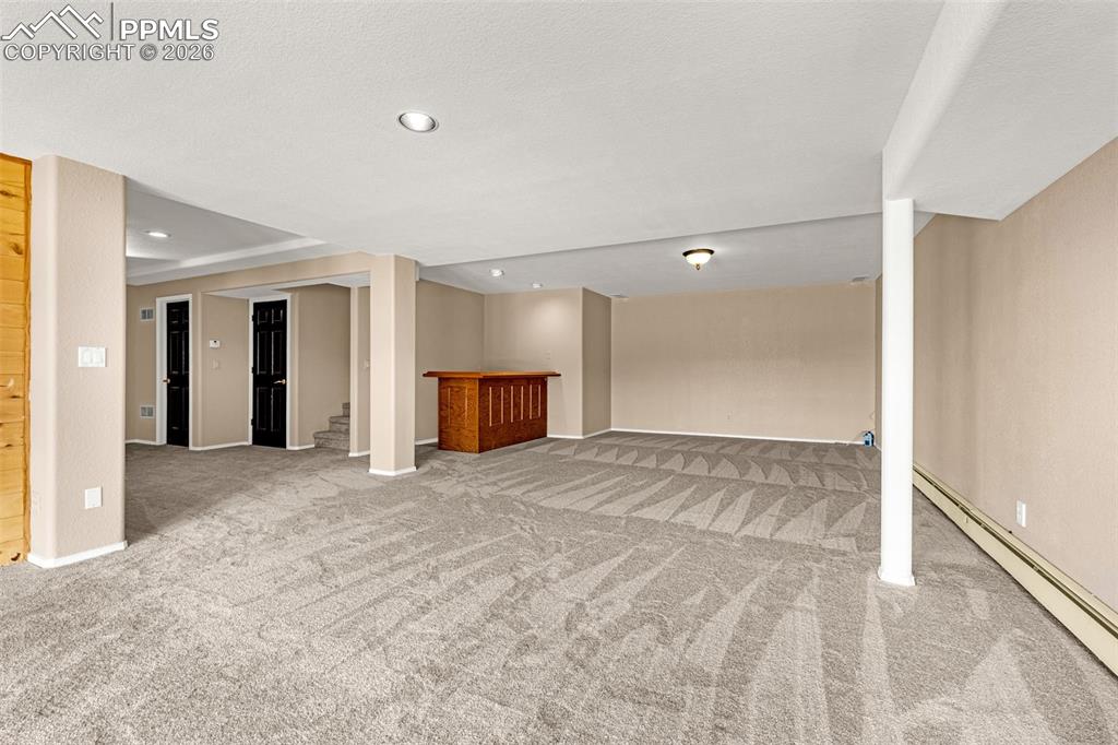 Image 35 of 48: Lower level family room & wet bar