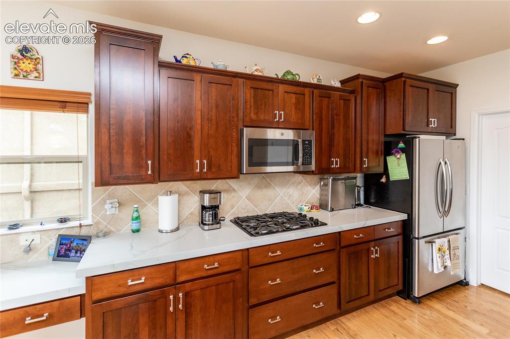 Image 15 of 48: Stainless steel appliances & warm colored cabinets.