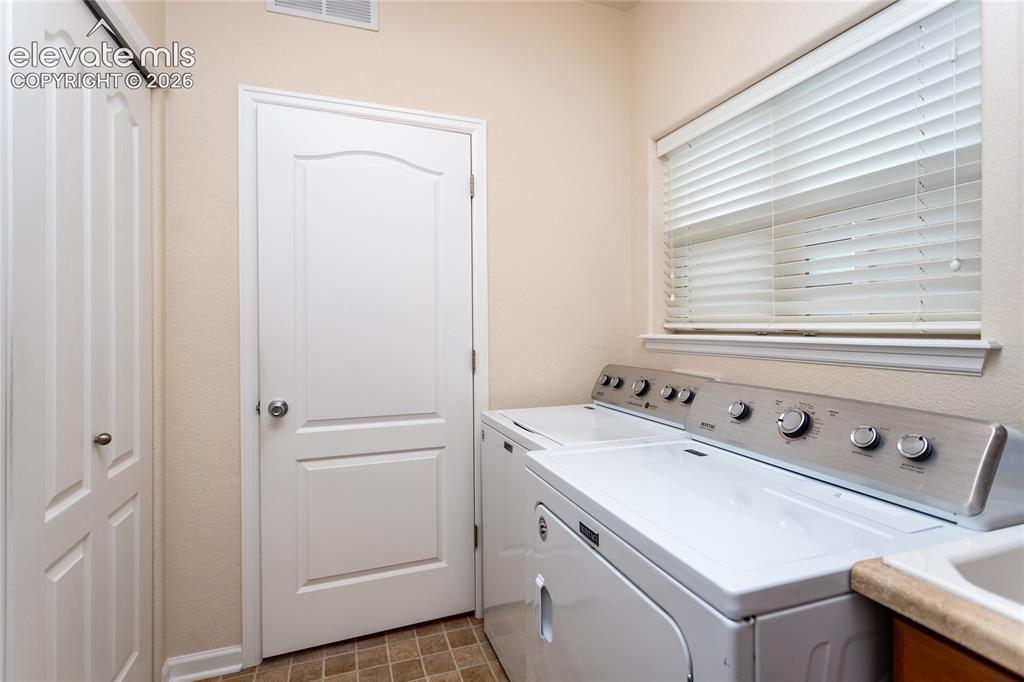 Image 38 of 48: Spacious laundry room with sink.