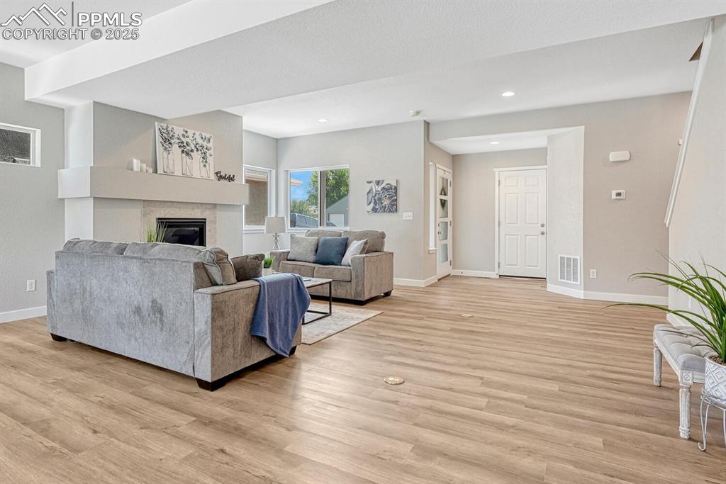 Image 2 of 50: Living room featuring light wood-style floors, a tile fireplace, and recess