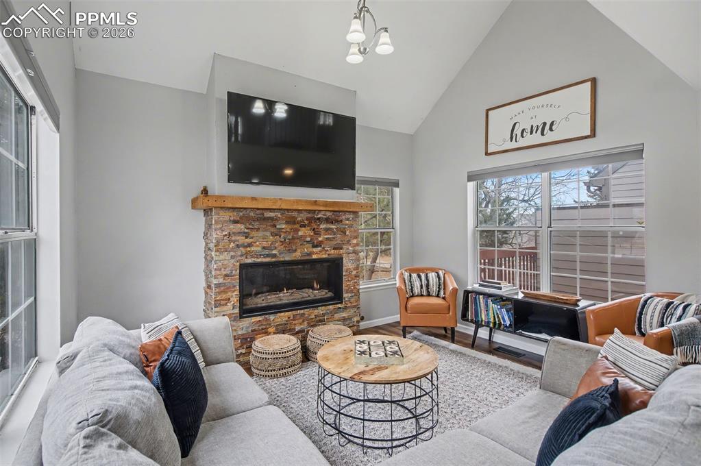 Image 10 of 36: Living room with stacked stone gas fireplace, vaulted ceilings to the loft 