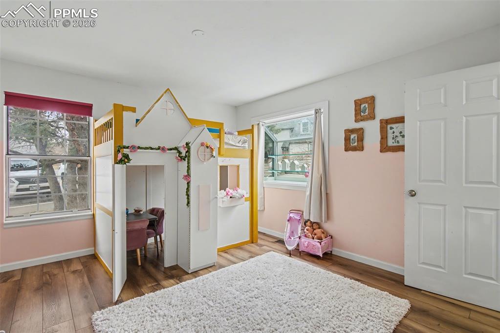 Image 14 of 36: Main level bedroom with LVP floors and newer garden style window.  