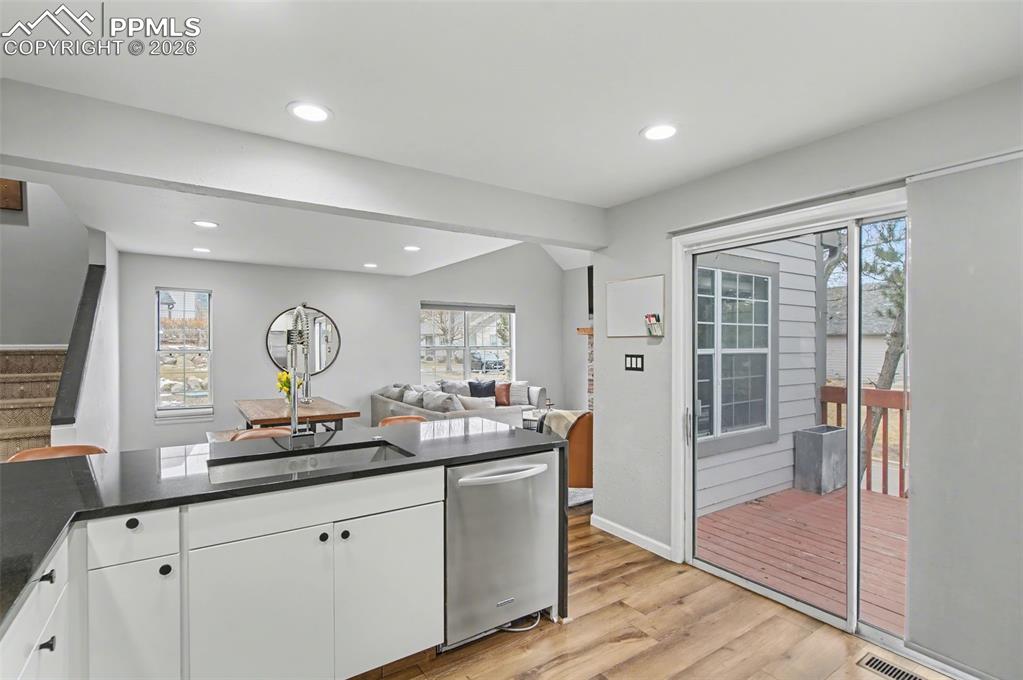 Image 7 of 36: Updated Kitchen with sleek flat-front cabinetry, waterfall-edge slab granit