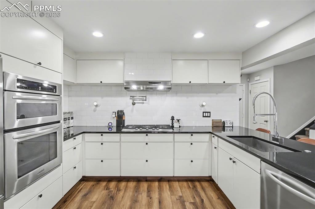 Image 8 of 36: Updated Kitchen with sleek flat-front cabinetry, waterfall-edge slab granit