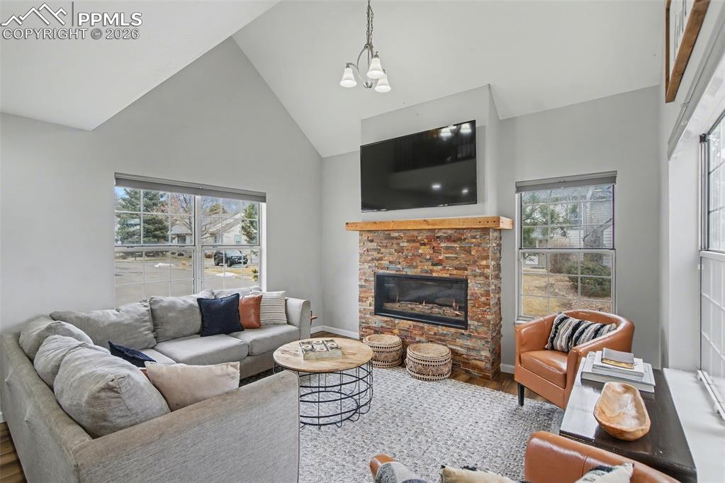 Image 9 of 36: Living room with stacked stone gas fireplace, vaulted ceilings to the loft 