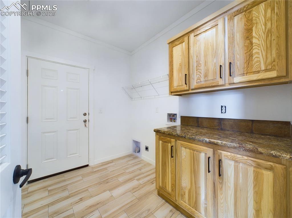 Image 43 of 50: Washroom with electric dryer hookup, washer hookup, cabinets