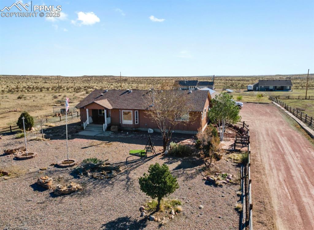 Image 2 of 21: View of front of house with a rural view, fence, and dirt driveway
