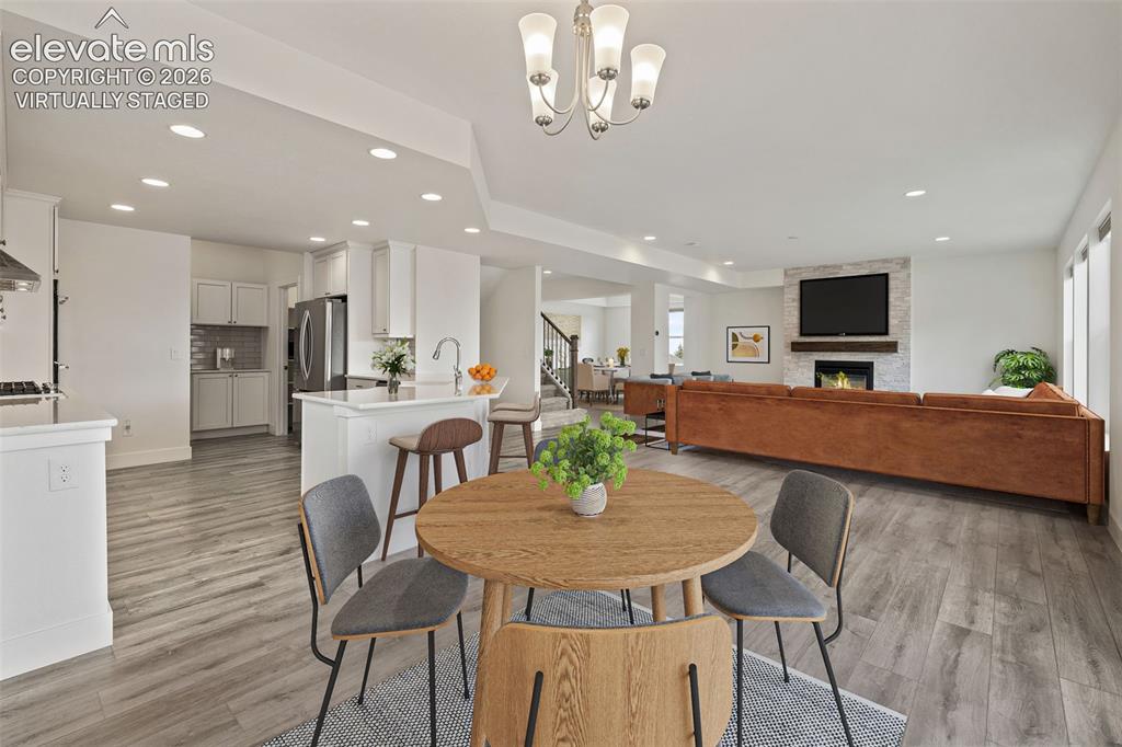 Image 11 of 50: Virtually Staged: Open-concept living space featuring wood-finish LVP floor