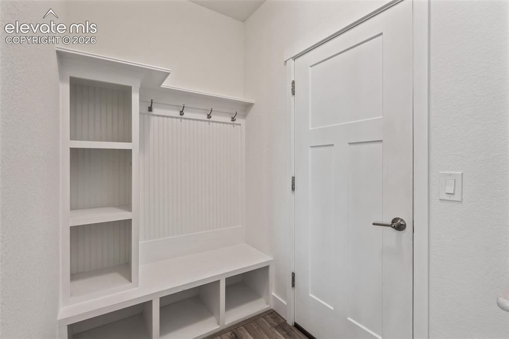 Image 18 of 50: Built-in storage bench with open shelving, beadboard backing, and integrate