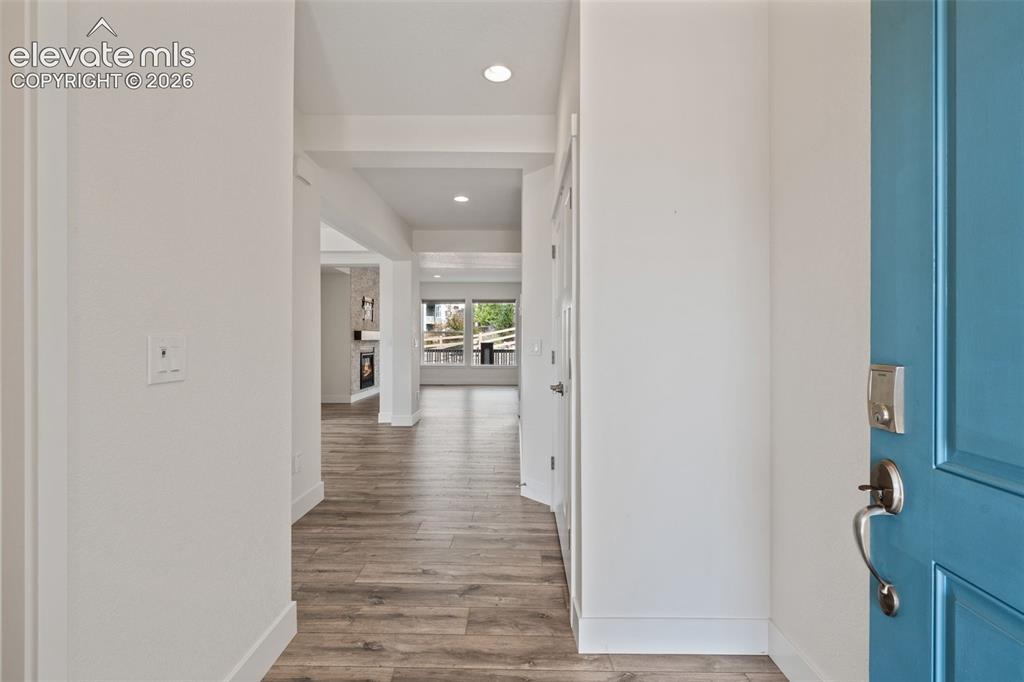 Image 2 of 50: Entryway featuring wood-finish LVP flooring, recessed lighting, white trim,