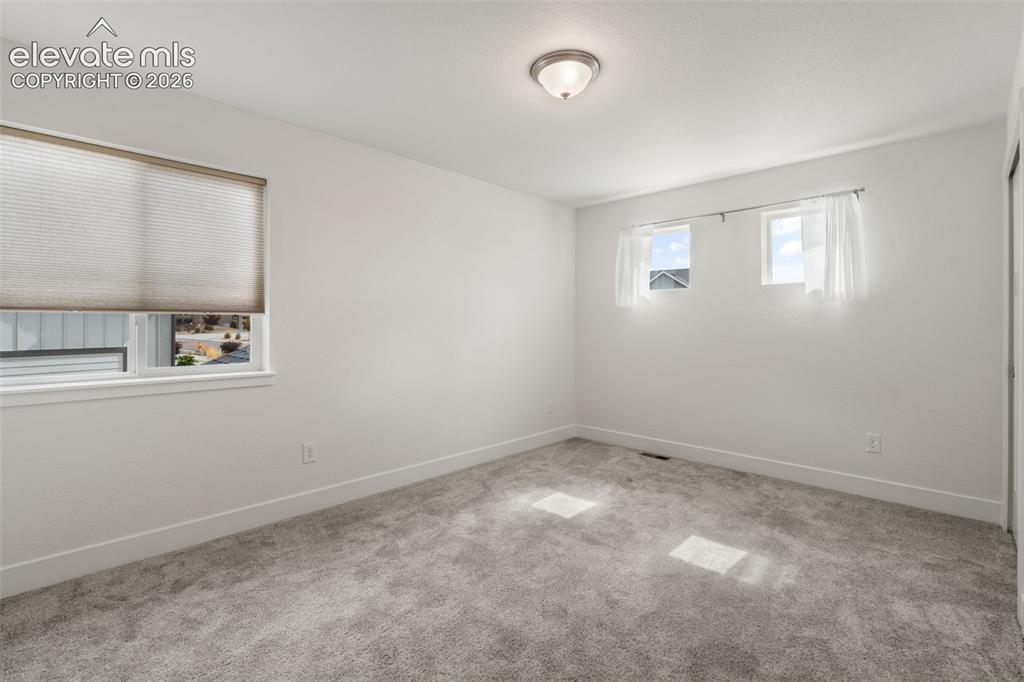 Image 29 of 50: Neutral wall color, wall-to-wall carpeting, and a flush mount ceiling light