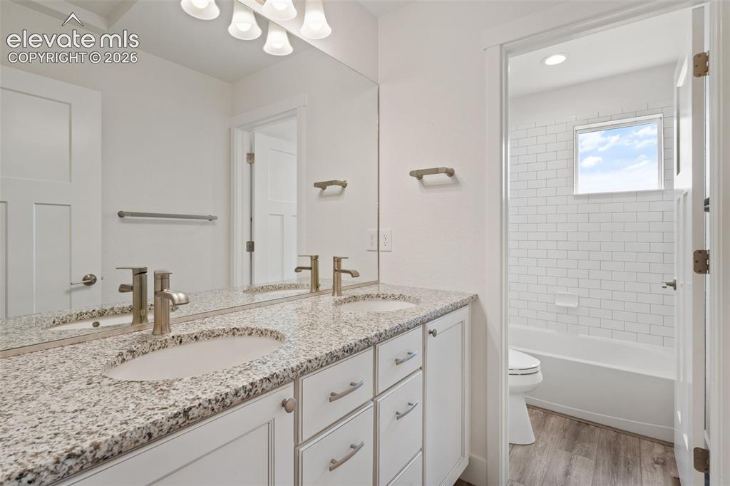 Image 31 of 50: Double vanity with granite countertop, undermount sinks, and brushed nickel