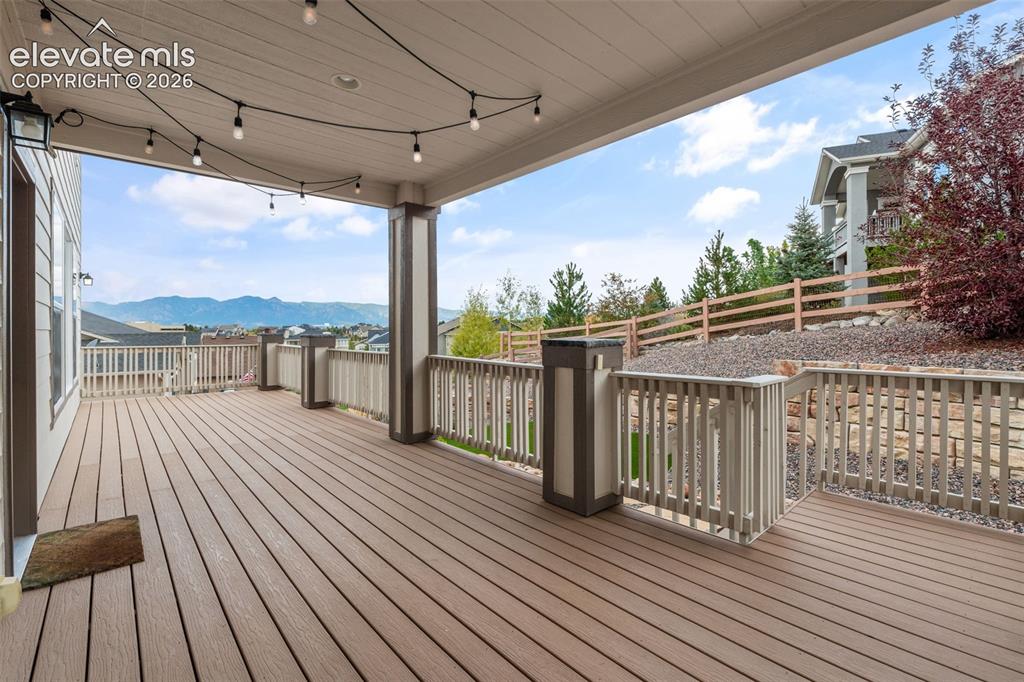 Image 41 of 50: Expansive covered deck featuring composite decking, painted railings, strin