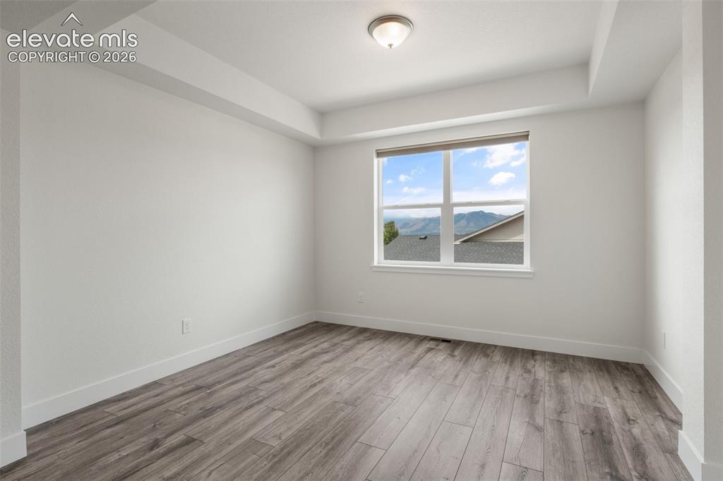 Image 6 of 50: Wood-finish LVP flooring, and a window with mountain views