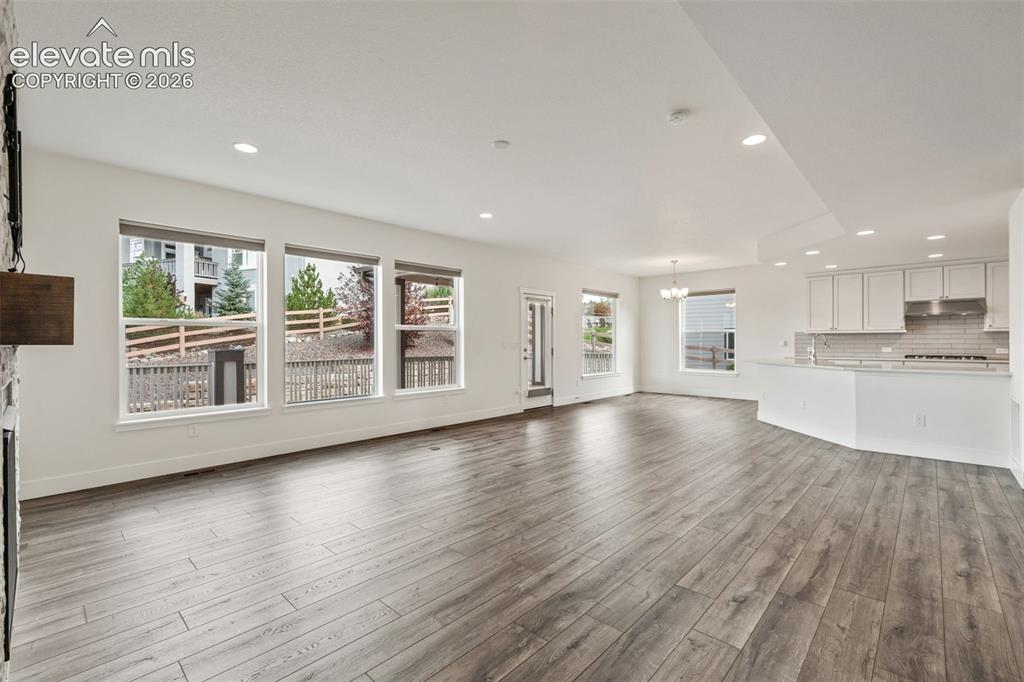 Image 7 of 50: Spacious open-concept living area featuring wood-finish LVP flooring, reces