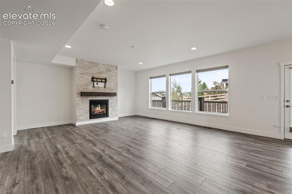 Image 8 of 50: Contemporary fireplace with a stacked stone surround and wood mantel