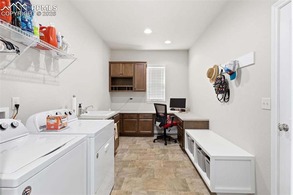Image 18 of 43: Expansive mud room with boot bench and desk area and utility sink