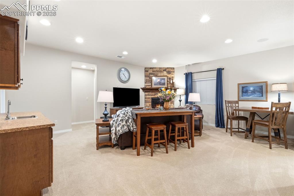 Image 25 of 43: Lower level family room with wetbar and refrigerator