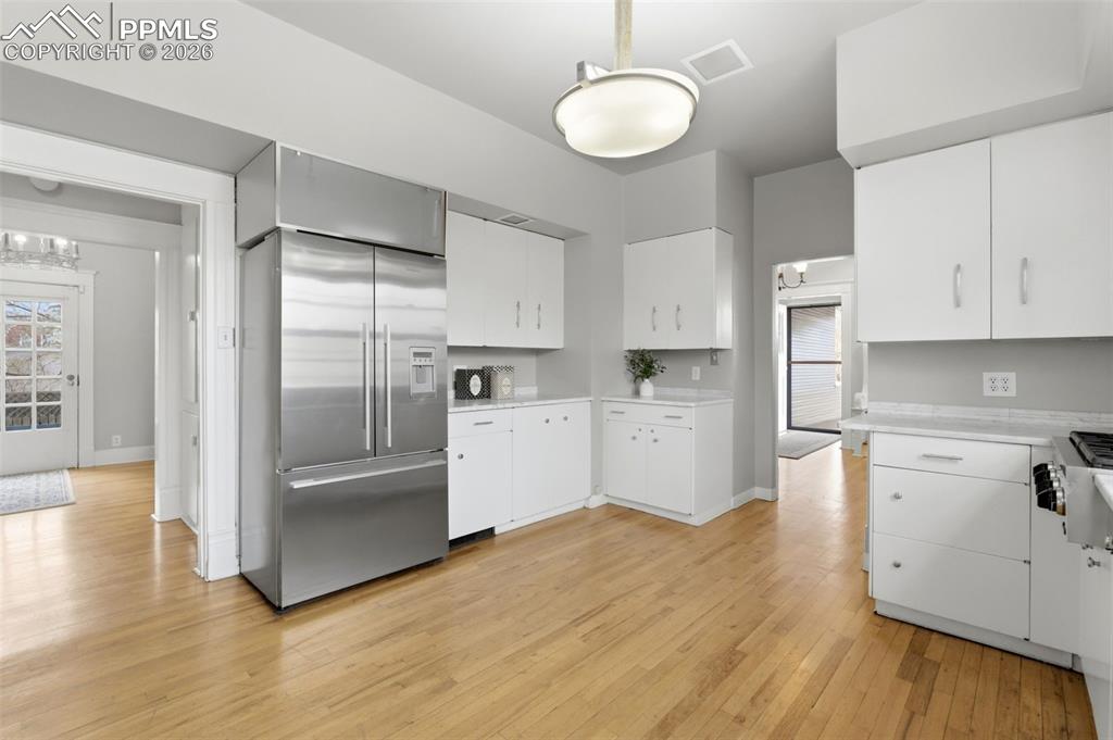 Image 12 of 39: Kitchen with Carrara Marble Tile and Hardwood Floors