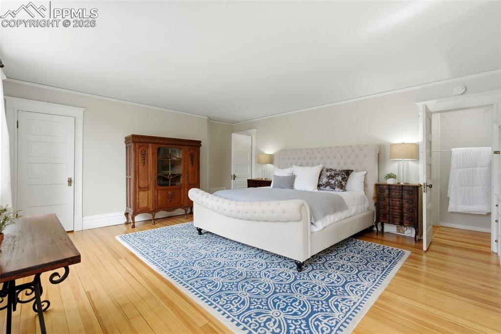 Image 14 of 39: Primary Bedroom with Walk-in Closet and Hardwood Floors