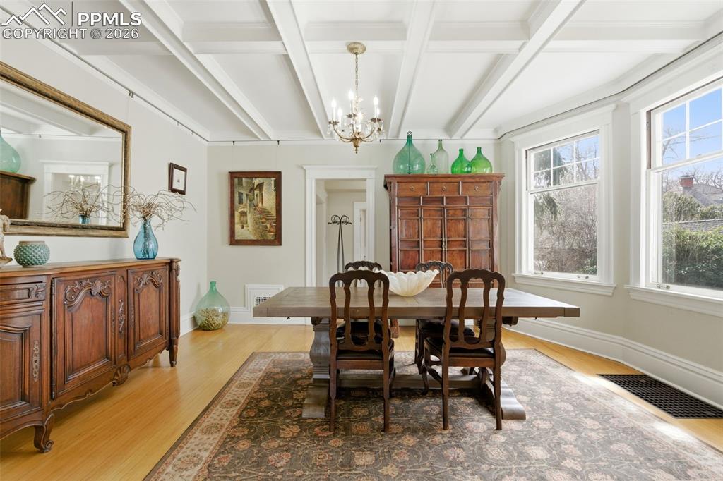 Image 7 of 39: Formal Dining Room with lots of natural light and coffered ceilings