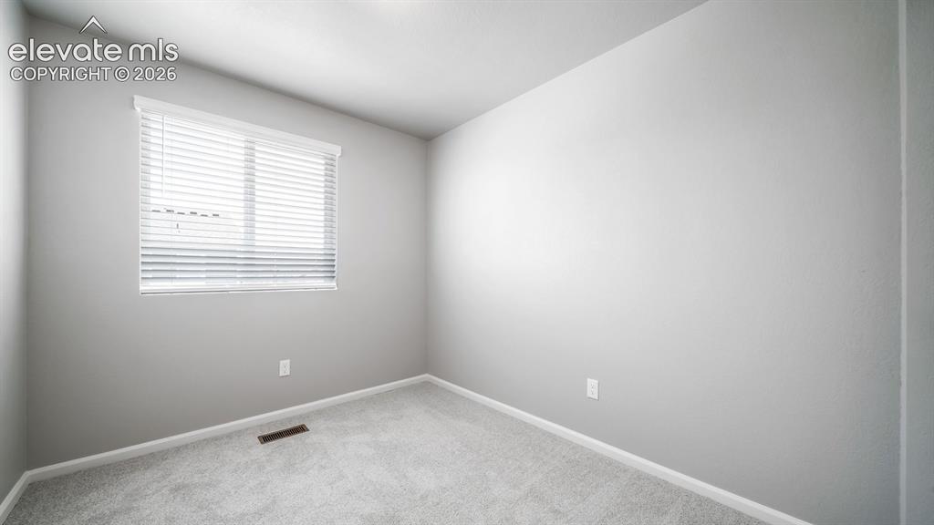 Image 11 of 28: Bright interior space featuring a window with white horizontal blinds, ligh