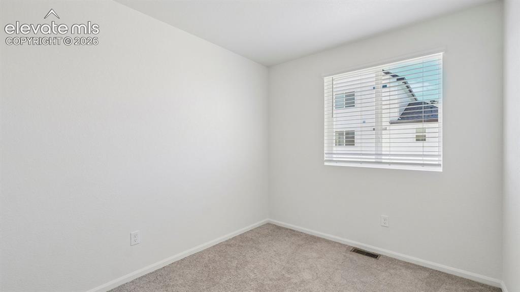 Image 11 of 28: White painted walls, neutral carpeting, and a window with blinds