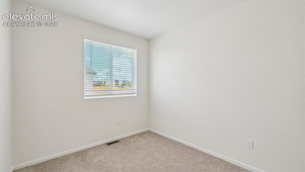 Image 14 of 28: Light-filled interior space featuring a window with horizontal blinds and t