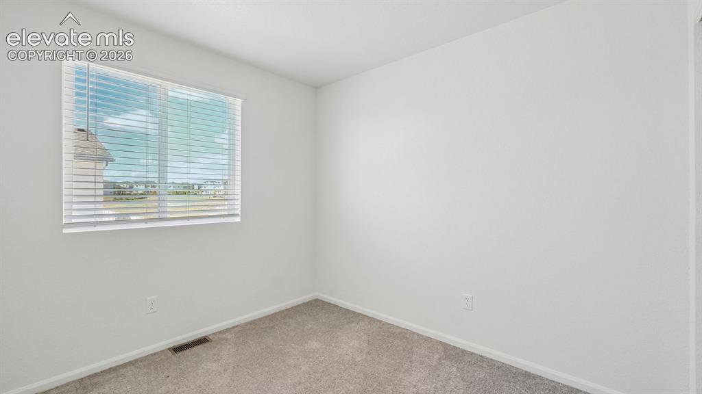 Image 15 of 28: Neutral paint palette, textured carpet, and a large window with horizontal