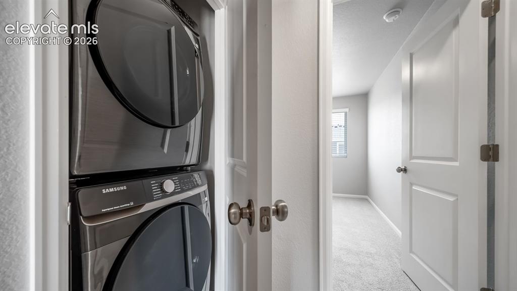 Image 17 of 28: Dedicated laundry closet featuring a stacked washer and dryer unit
*Photos