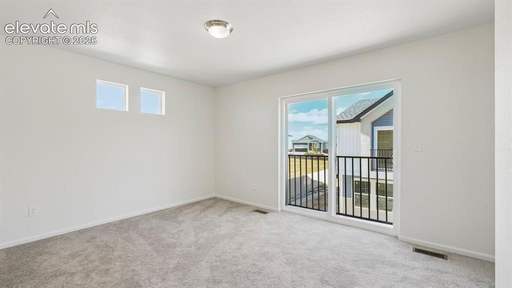 Image 19 of 28: Sliding glass door opening to a balcony with black metal railings