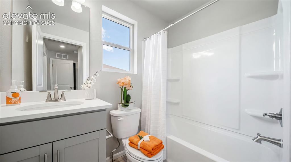 Image 2 of 28: Bathroom featuring a light gray vanity with a white countertop and undermou